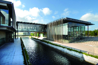 長崎県美術館の、ガラスと木が調和したモダンな建物と脇を流れる水路