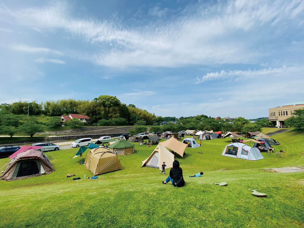 和水江田川カヌー・キャンプ場の、青空の下の広々とした芝生のフリーサイト