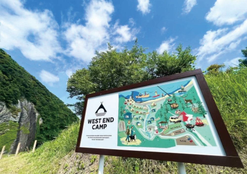 青空の下に立つWEST END CAMPの案内看板とキャンプ場のイラストマップ