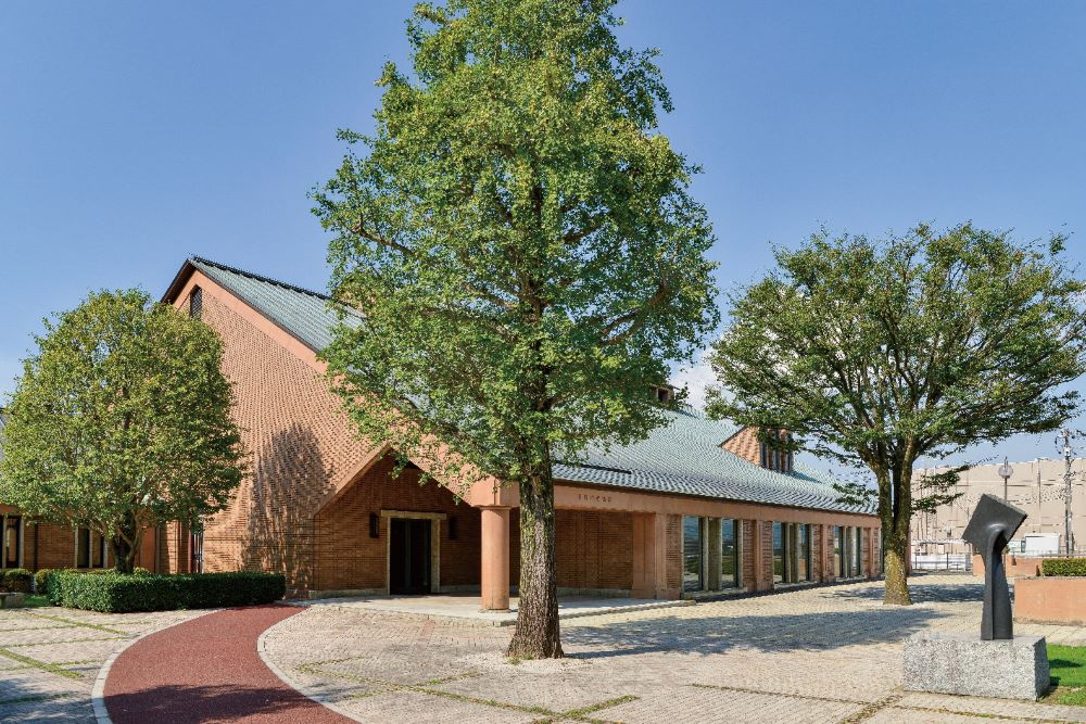 田川市美術館の、緑に囲まれたレンガ造りの建物と野外彫刻