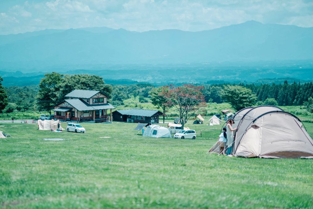 ボイボイキャンプ場の広大な草原と、遠くに広がる山々の風景