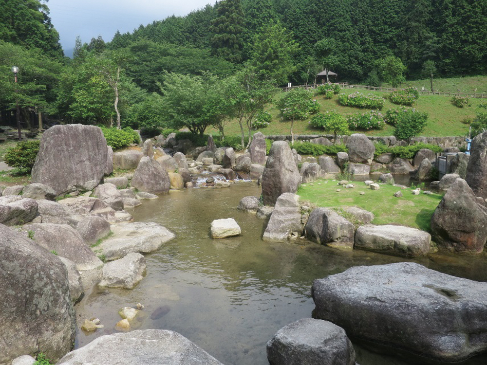 一本松公園の岩と緑に囲まれた日本庭園の池