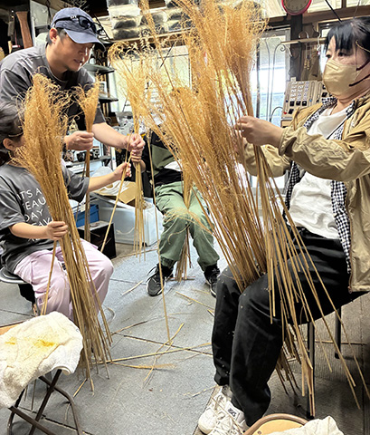 土日のみ開講するものづくりの体験型施設。伝統工芸の体験をはじめ、デザイナーの高光俊信さんから直接指導を受けられる。阿蘇に自生するススキを使ったほうき作りでは、約30㎝のほうきを編み上げる。サッと掃くのに便利。