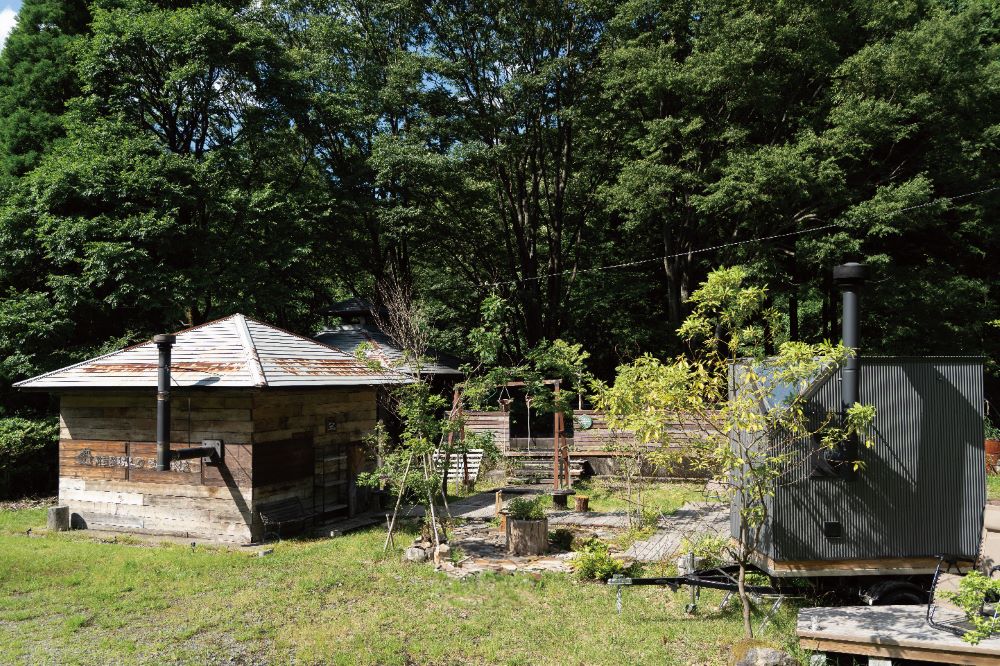 ゲストハウスLAMP豊後大野の、森の中に佇むサウナ小屋と移動式のサウナトレーラー