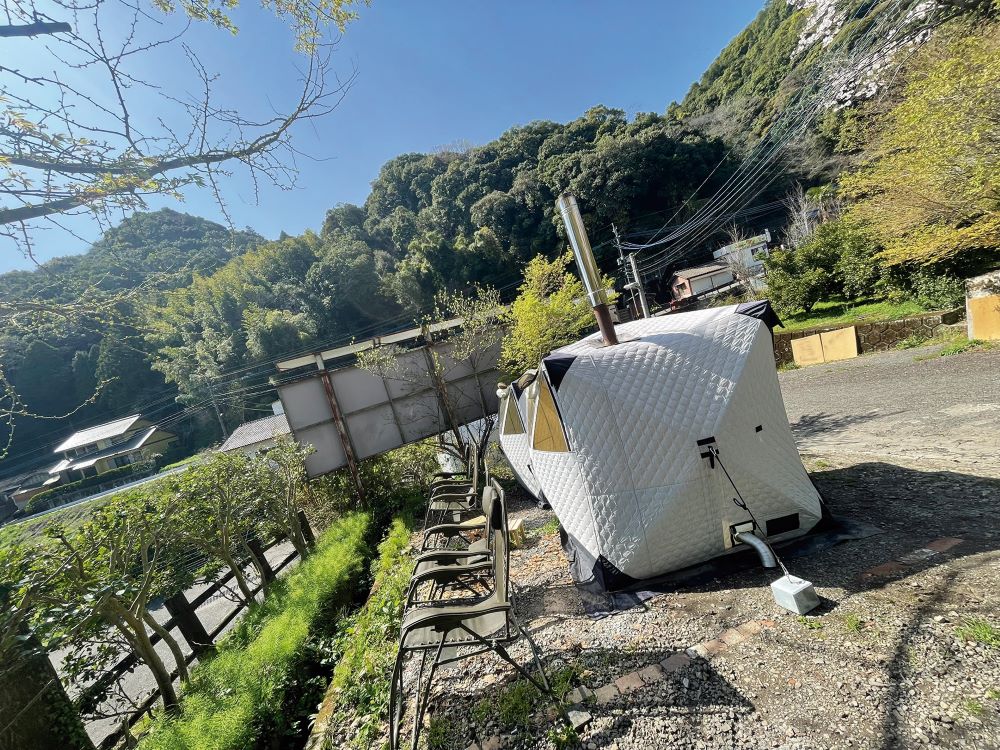 在りのままの、緑豊かな山を背景に設置されたテントサウナ