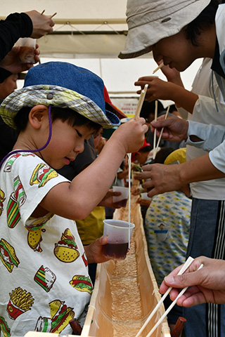 390年以上の歴史と伝統を誇る神埼市の特産品「神埼そうめん」を広く知ってもらおうと、毎年GWに開催されているグルメイベント。なかでも、青竹を使って流す「そうめん流し」が大人から子どもまで大人気。￥500（つゆ1杯）の食べ放題という大盤振る舞いもうれしい。